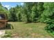 A spacious backyard with green grass and mature trees, extending from the patio of a house at 4381 Laurian Nw Dr, Kennesaw, GA 30144