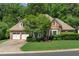 Charming brick home featuring a two-car garage, well-manicured lawn, and lush landscaping at 4381 Laurian Nw Dr, Kennesaw, GA 30144