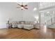Spacious living room featuring hardwood floors and a comfortable, oversized sectional sofa with staircase and entry in background at 4381 Laurian Nw Dr, Kennesaw, GA 30144