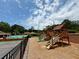 A community playground featuring a wooden play structure, slides, and a pool in the background at 4381 Laurian Nw Dr, Kennesaw, GA 30144