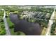 Aerial view of community with houses surrounding a beautiful pond with mature trees at 675 Mallard Cv, Loganville, GA 30052