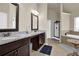 Bathroom featuring granite counters, wood cabinets, tiled floors, a tub and shower at 675 Mallard Cv, Loganville, GA 30052