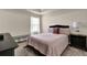 Comfortable bedroom featuring a plush pink quilt, tray ceiling, and natural light at 675 Mallard Cv, Loganville, GA 30052