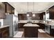 Well-equipped kitchen features dark wood cabinetry, granite countertops, and stainless steel appliances at 675 Mallard Cv, Loganville, GA 30052