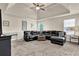 Spacious living room featuring a ceiling fan, and a comfortable, oversized black leather sofa at 675 Mallard Cv, Loganville, GA 30052