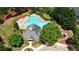 Aerial view of a community pool surrounded by mature landscaping, lounge chairs, and a clubhouse at 675 Mallard Cv, Loganville, GA 30052