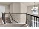 View of carpeted staircase featuring decorative metal railing and chandelier in this home at 675 Mallard Cv, Loganville, GA 30052