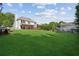 Wide backyard with lush lawn, mature trees, playhouse, and a spacious deck perfect for entertaining at 7025 Coffield Ct, Cumming, GA 30041