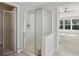 Modern bathroom with a glass shower door and a glimpse into the bright, open bedroom at 7025 Coffield Ct, Cumming, GA 30041