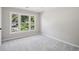 Clean bedroom with window and neutral colored walls and soft carpeting at 7025 Coffield Ct, Cumming, GA 30041