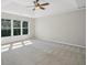 Spacious main bedroom with tray ceilings, a fan, and lots of natural light streaming through the large window at 7025 Coffield Ct, Cumming, GA 30041