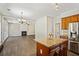 An open concept kitchen with stainless steel appliances and a granite island flows into the cozy living room at 7025 Coffield Ct, Cumming, GA 30041
