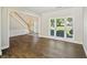 Bright living room with hardwood floors, staircase, and large windows at 7025 Coffield Ct, Cumming, GA 30041
