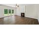 Bright living room features a fireplace, ceiling fan, and a large window overlooking the lush backyard at 7025 Coffield Ct, Cumming, GA 30041