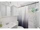 Clean and well-lit bathroom with marble tiling, modern sink, and a shower with a decorative curtain at 905 Scott Sw Ln, Marietta, GA 30008