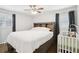 Comfortable bedroom with hardwood floors, ceiling fan, and a crib, perfect for a Gathering at 905 Scott Sw Ln, Marietta, GA 30008