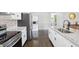 Updated kitchen featuring stainless steel appliances, granite countertops, white cabinets, and dark hardwood floors at 905 Scott Sw Ln, Marietta, GA 30008