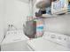 This laundry room is equipped with a washer, dryer, water heater, and storage shelves at 905 Scott Sw Ln, Marietta, GA 30008