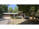 Charming single-story home featuring a covered porch, attached garage, and mature trees at 224 Potts Se Rd, Conyers, GA 30094