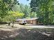 Secluded single-story home featuring a gravel driveway, deck, RV parking, and an attached two car garage at 224 Potts Se Rd, Conyers, GA 30094