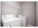 A laundry room with white washer and dryer, plus a wire rack shelf for added storage at 2544 Castellan Dr, Atlanta, GA 30316