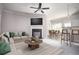 Bright, staged living room with a fireplace, ceiling fan, and open layout to dining area at 2544 Castellan Dr, Atlanta, GA 30316