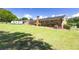 View of the rear brick house with expansive backyard, an air conditioning unit, and some trees at 4172 N Martin Way, Lithia Springs, GA 30122