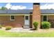 Brick home exterior with patio, black roof, shrubs, and expansive grassy backyard space at 4172 N Martin Way, Lithia Springs, GA 30122