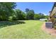 Backyard featuring a large grassy area, mature trees, and an air conditioning unit at 4172 N Martin Way, Lithia Springs, GA 30122
