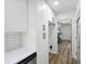 Hallway with white cabinets, modern appliances, and luxury vinyl plank flooring at 4172 N Martin Way, Lithia Springs, GA 30122