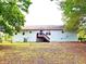 A view of the backyard featuring the back of the house, a deck, and some large trees at 60 Parkman Trl, Covington, GA 30016