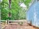 A view of the backyard, featuring a fence, a side of the house, and a lot of trees at 60 Parkman Trl, Covington, GA 30016
