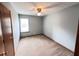 Cozy bedroom features neutral carpeting, ceiling fan, and natural light at 60 Parkman Trl, Covington, GA 30016