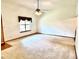 Spacious living room with neutral carpet, ceiling fan, and bright natural light from window at 60 Parkman Trl, Covington, GA 30016