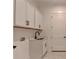 Modern laundry room features white cabinets, a sink, and sleek black hardware at 2750 Herrington Dr, Cumming, GA 30041