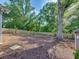 View of the spacious backyard featuring a towering tree, wooden fence, and natural backdrop at 3215 Woodview Se Dr, Smyrna, GA 30082
