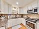 Well-lit kitchen with white cabinets, granite counters, and stainless steel appliances at 3215 Woodview Se Dr, Smyrna, GA 30082
