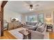 Cozy living room features a comfortable gray sofa, a ceiling fan, and natural light from the window at 3215 Woodview Se Dr, Smyrna, GA 30082