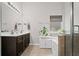Bright bathroom featuring a double sink vanity, tile flooring, a plant and large mirror at 5575 Hedge Brook Dr, Cumming, GA 30028