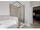 Well-lit bathroom with a soaking tub and separate glass enclosed shower stall at 5575 Hedge Brook Dr, Cumming, GA 30028