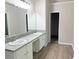 Bathroom featuring dual sinks, granite countertop, and a large mirror at 7097 Cavender Sw Dr, Atlanta, GA 30331