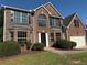 Beautiful brick home featuring a two-car garage, landscaped yard, and striking architectural details at 7097 Cavender Sw Dr, Atlanta, GA 30331