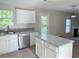 Well-lit kitchen with white cabinetry, a central island, granite countertops, and modern appliances at 7097 Cavender Sw Dr, Atlanta, GA 30331