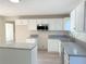 Bright kitchen featuring white cabinets, gray granite countertops, and stainless steel appliances at 7097 Cavender Sw Dr, Atlanta, GA 30331