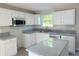 Bright kitchen featuring white cabinets, stainless appliances, and granite countertops at 7097 Cavender Sw Dr, Atlanta, GA 30331