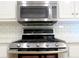 Kitchen with stainless steel gas range, microwave, and white subway tile backsplash at 21 Devin Lane Ln, Euharlee, GA 30145