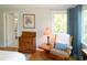 Bedroom sitting area with a cozy chair, side table, and large window overlooking the yard at 21 Devin Lane Ln, Euharlee, GA 30145