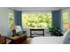 Serene bedroom with a large window, a cozy chair, and a view of lush greenery, promoting relaxation at 21 Devin Lane Ln, Euharlee, GA 30145