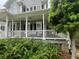 Inviting front porch is partially visible behind lush green shrubbery and mature shade tree at 21 Devin Lane Ln, Euharlee, GA 30145