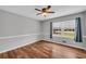Neutral bedroom featuring wood floors, large window and light-colored walls at 3642 S Bogan Rd, Buford, GA 30519